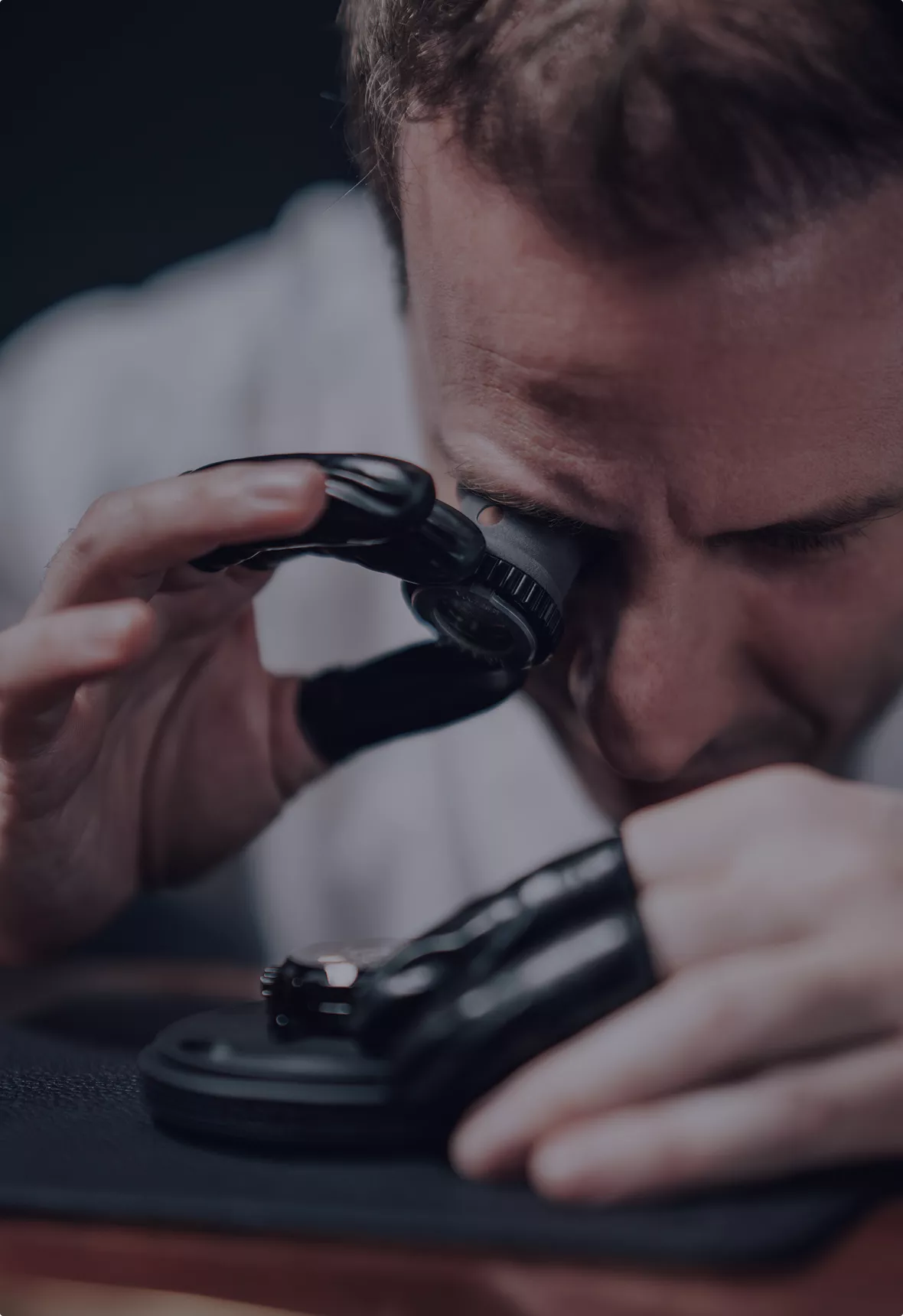 Frédéric Jouvenot examining a movement through a watchmaker's loupe